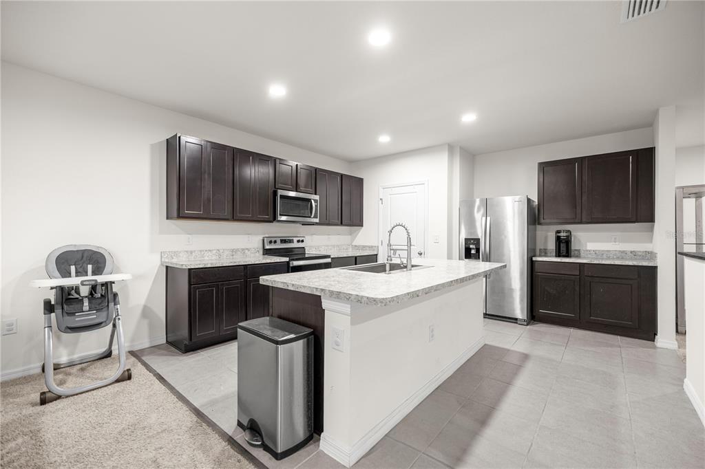 3833 Southeast 98th Place Belleview, FL 34420 - Photo 18 of 34 a kitchen with a sink cabinets and stainless steel appliances