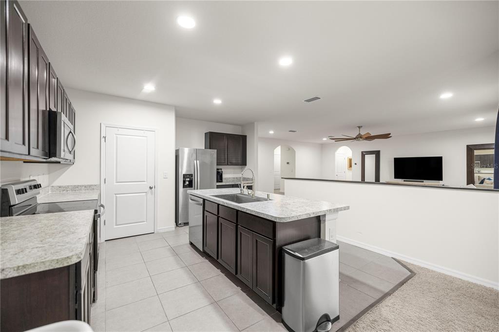 3833 Southeast 98th Place Belleview, FL 34420 - Photo 19 of 34 a kitchen with stainless steel appliances granite countertop a sink stove and refrigerator