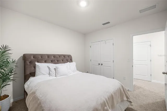 a bedroom with a large bed and a potted plant