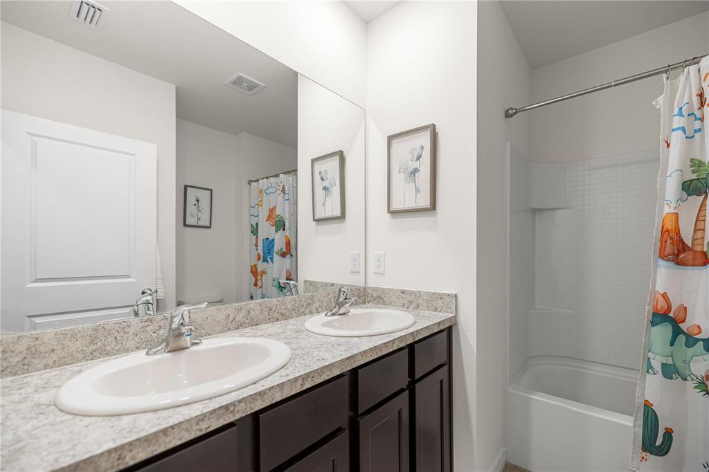 3833 Southeast 98th Place Belleview, FL 34420 - Photo 22 of 34 a bathroom with a granite countertop sink and a mirror