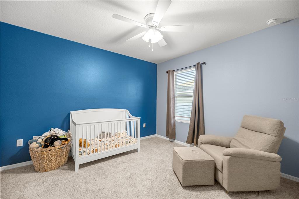 3833 Southeast 98th Place Belleview, FL 34420 - Photo 23 of 34 a bedroom with a bed and a chandelier