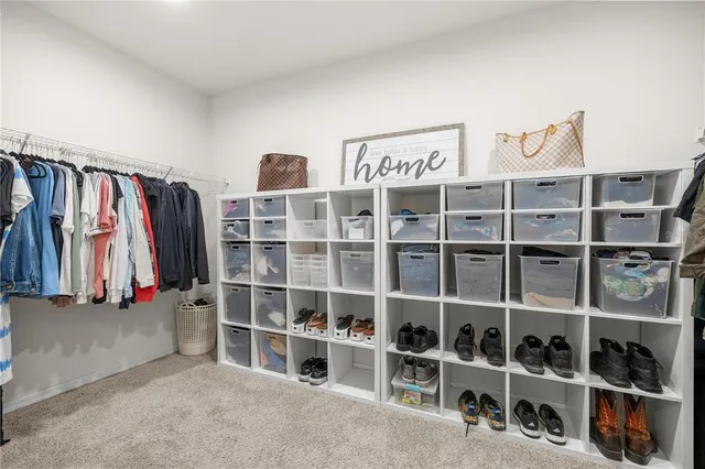 a view of walk in closet with clothes and shoes