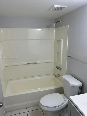 a kitchen with white cabinets and black appliances