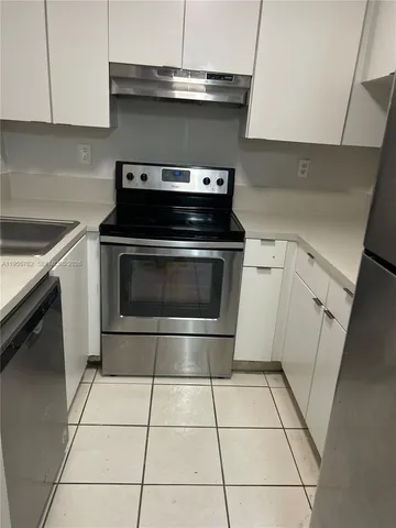 a stove top oven sitting inside of a kitchen