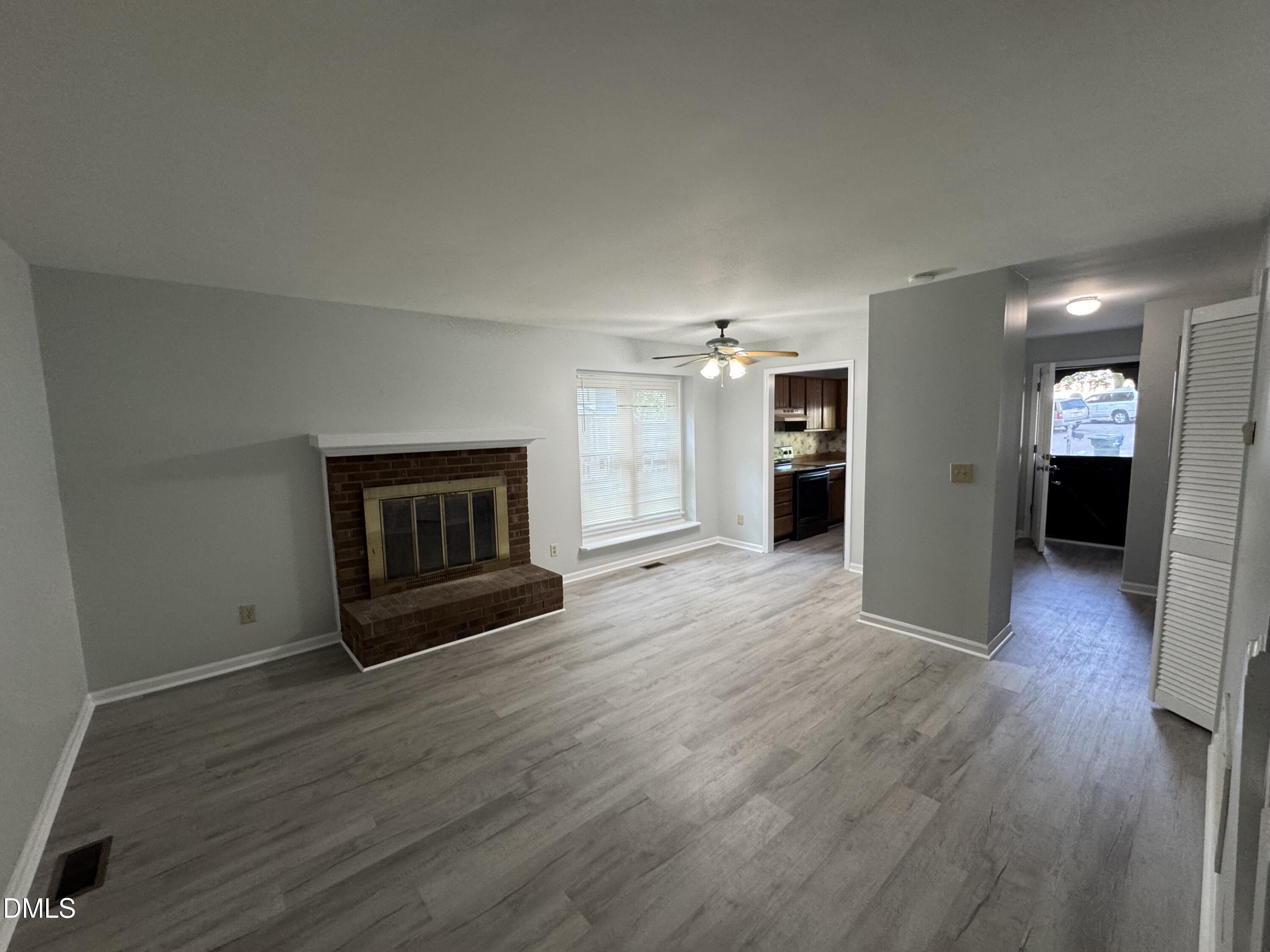4200 Bertram Drive Raleigh, NC 27604 - Photo 5 of 16 an empty room with wooden floor and fireplace