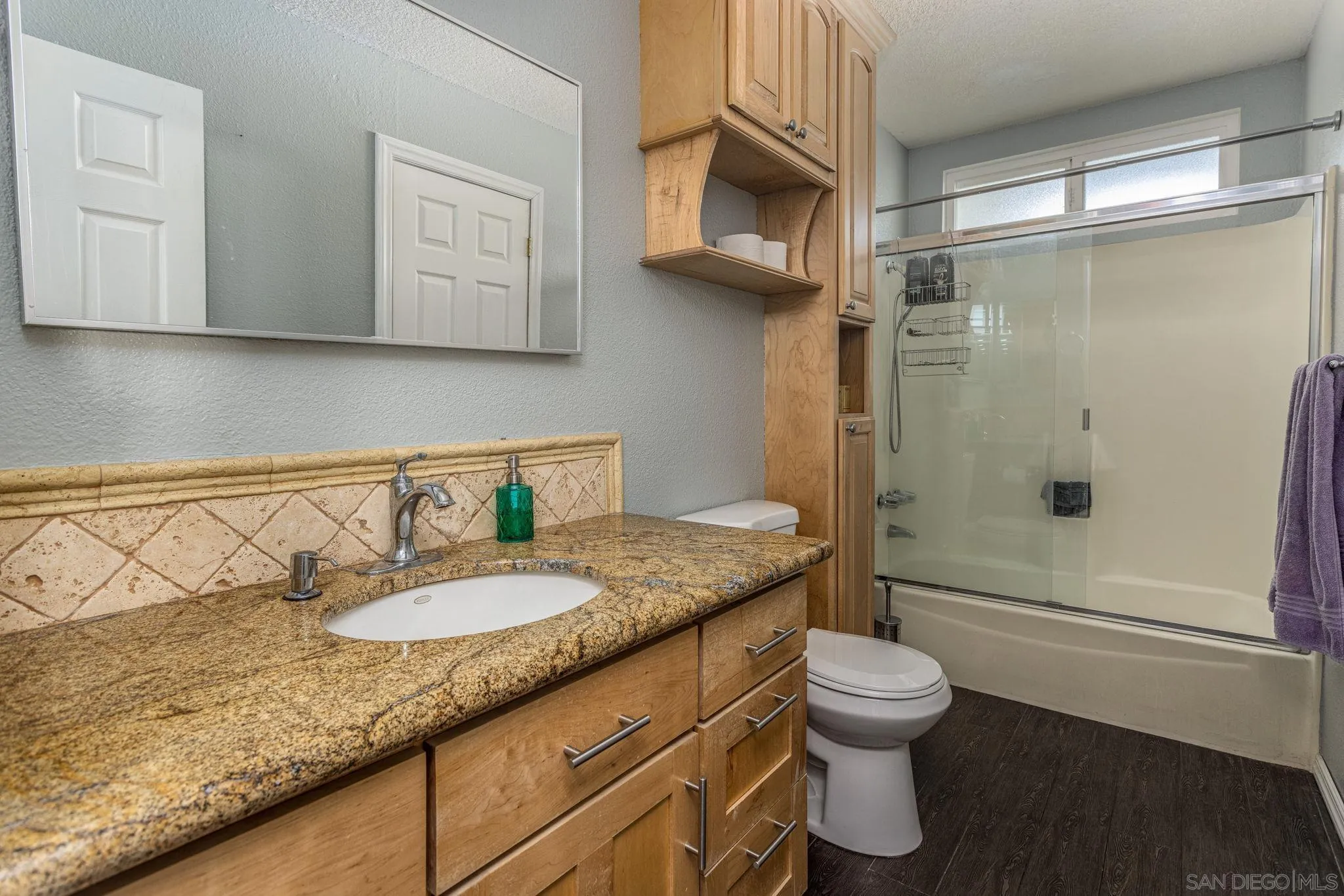 532 Kempton Street Spring Valley, CA 91977 - Photo 12 of 30 a bathroom with a granite countertop sink a toilet and shower