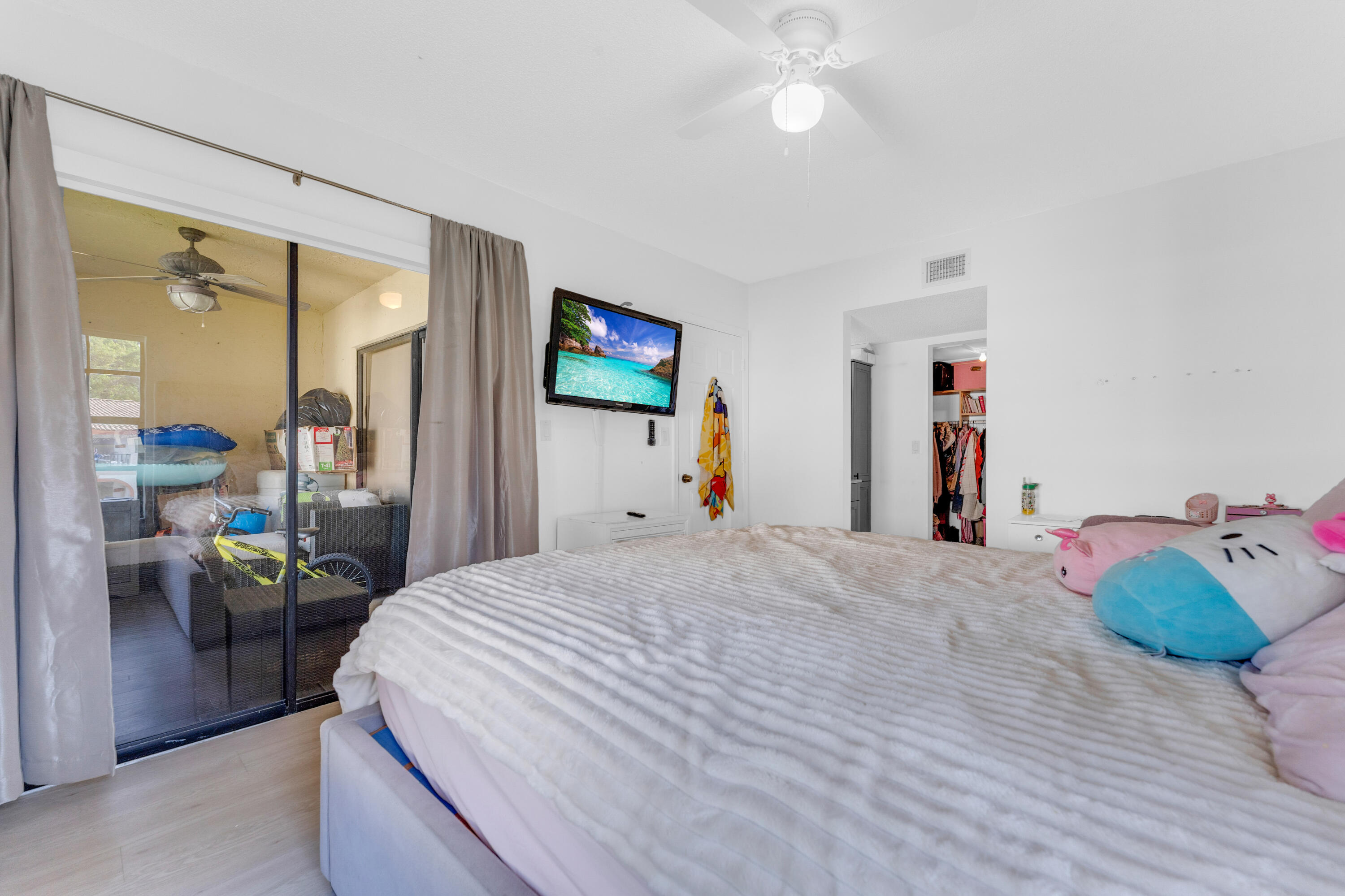 2800 Palmwood Terrace, Unit 2190 Boca Raton, FL 33431 - Photo 16 of 42 a bedroom with a bed and a chandelier