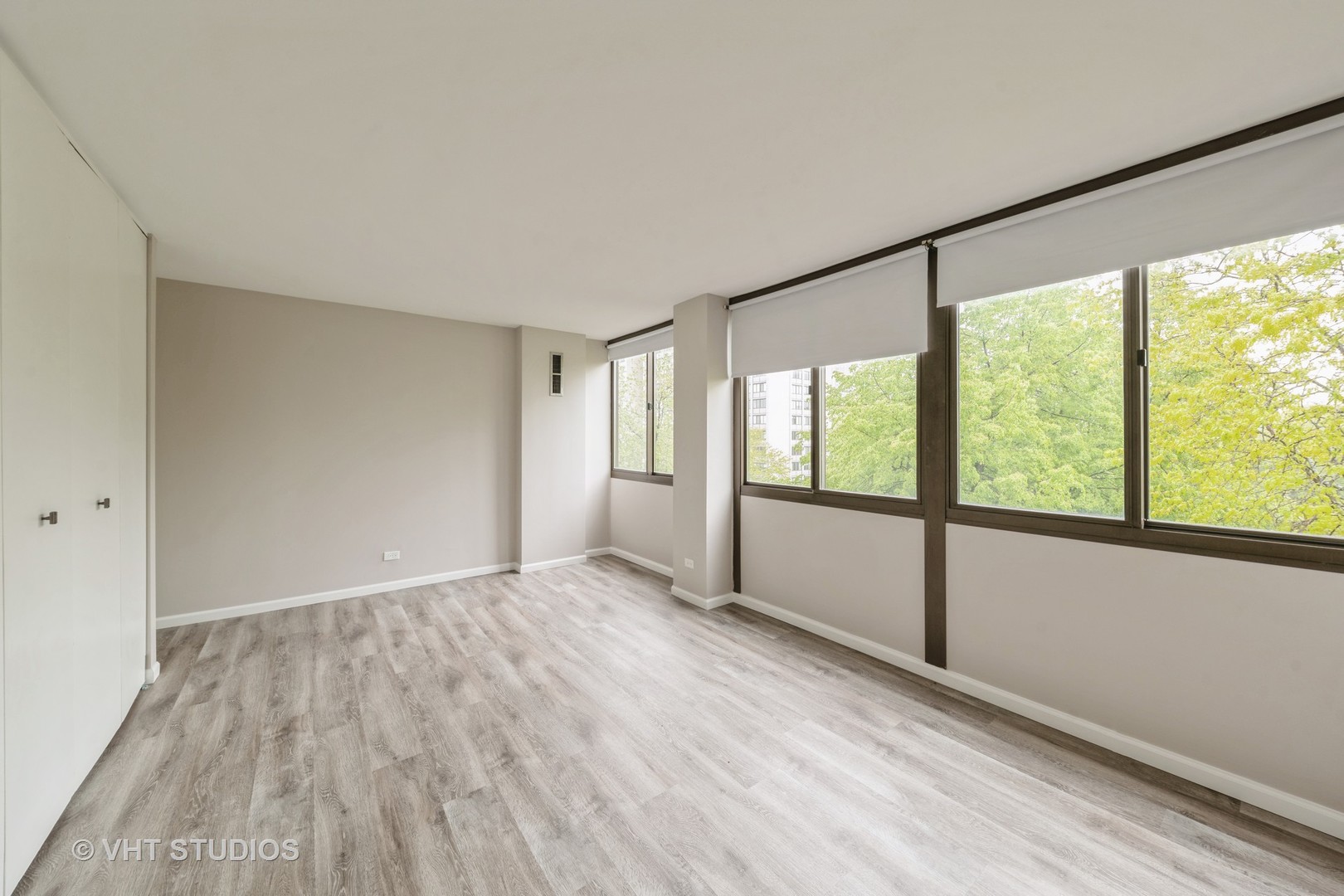 4850 South Lake Park Avenue, Unit 512 Chicago, IL 60615 - Photo 14 of 18 a view of an empty room with wooden floor and a window