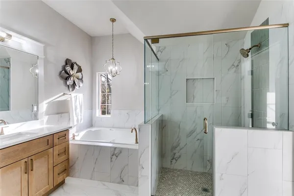 a bathroom with a tub sink shower and mirror