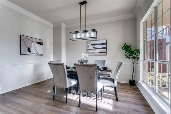 a dining room with furniture potted plants and wooden floor