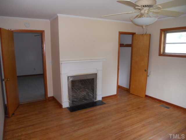 8515 Ten-Ten Road Raleigh, NC 27603 - Photo 5 of 8 a view of a livingroom with a fireplace and a ceiling fan