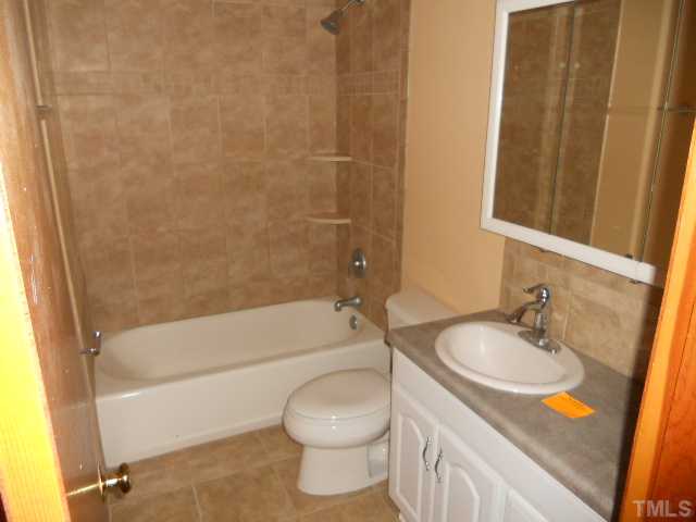 8515 Ten-Ten Road Raleigh, NC 27603 - Photo 6 of 8 a bathroom with a granite countertop sink toilet and shower