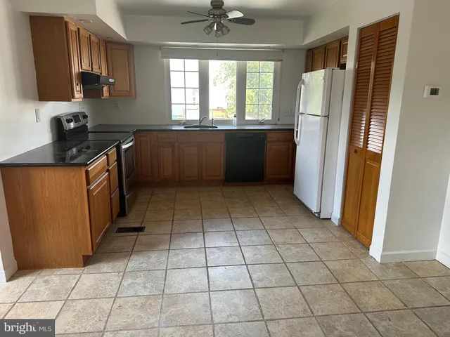 a kitchen with a refrigerator a stove a microwave and cabinets