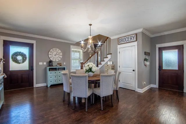 a dining room with furniture a chandelier and wooden floor