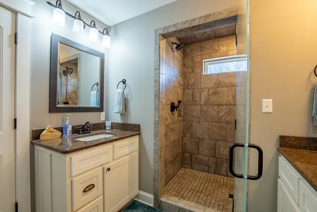 a bathroom with a sink a toilet and shower