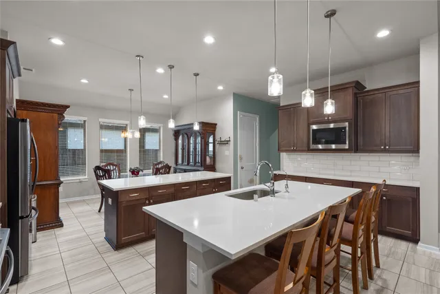 a large kitchen with a table and chairs