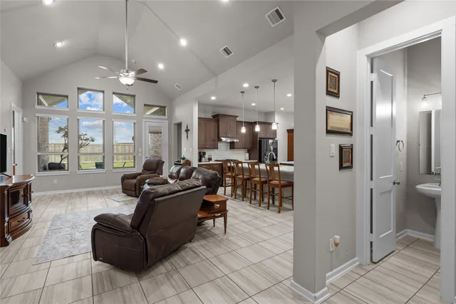 a living room with furniture a large window and stainless steel appliances