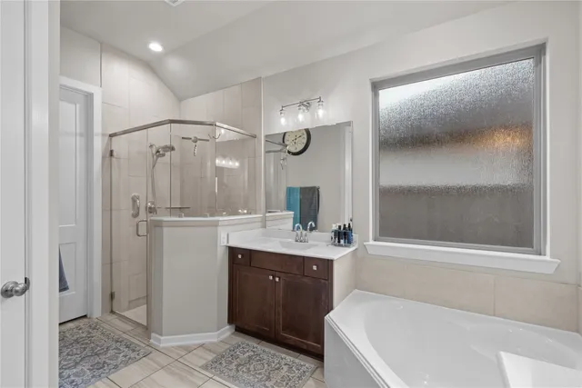 a bathroom with a tub a sink and mirror