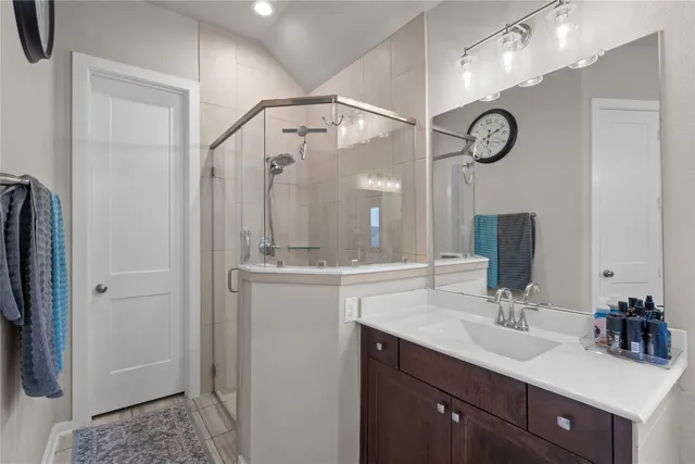 a bathroom with a double vanity sink mirror and shower