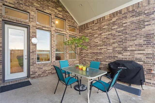 a view of a patio with a table and chairs