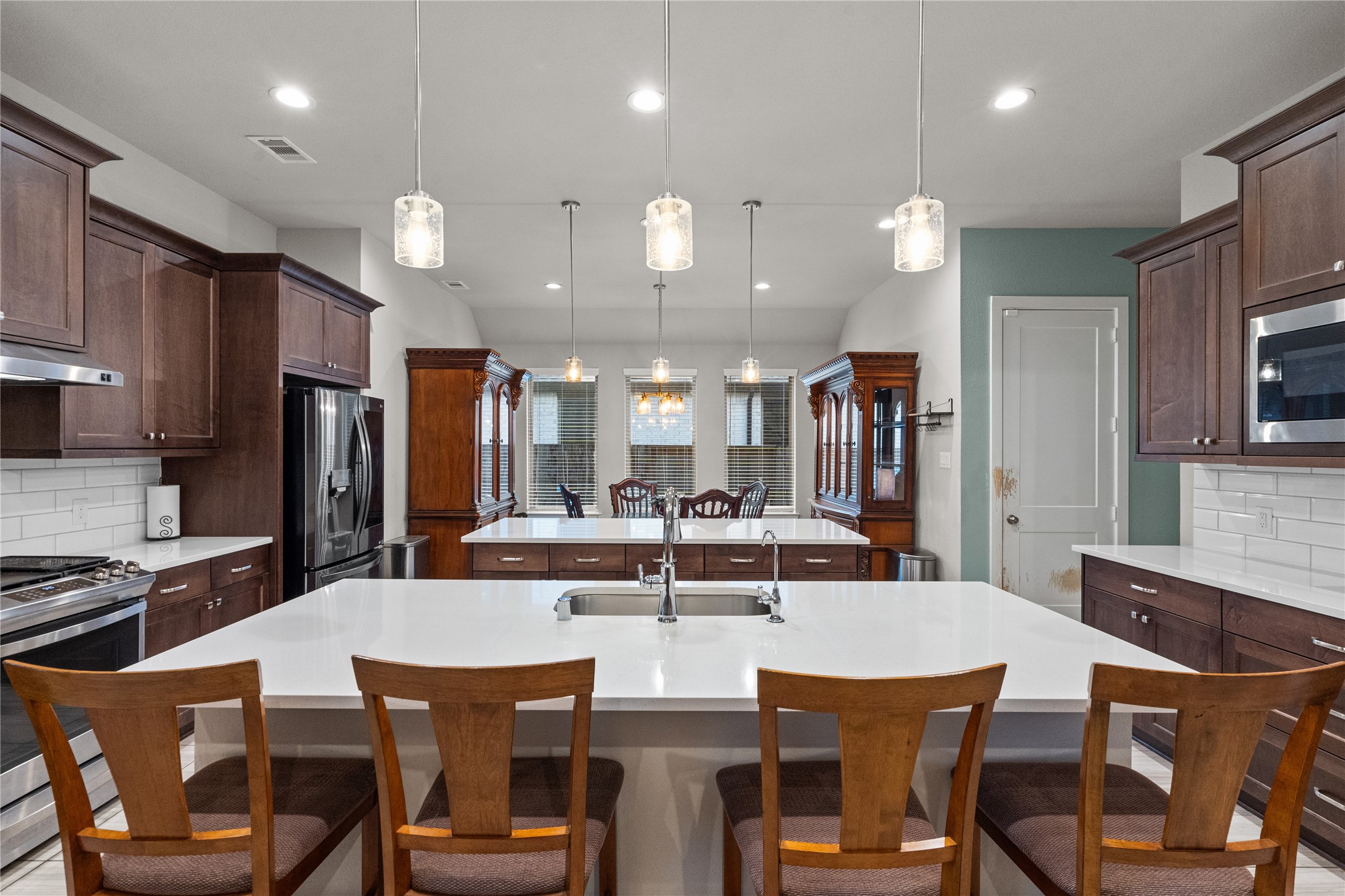 5814 Lavaca Lane Manvel, TX 77578 - Photo 10 of 37 a kitchen with stainless steel appliances kitchen island granite countertop a kitchen island and chairs in it