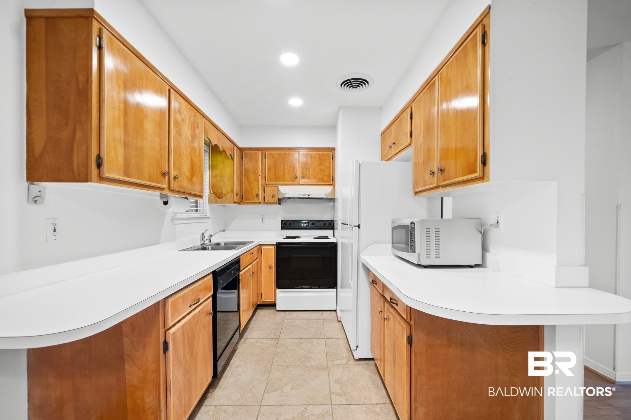 280 Thrift Street Mobile, AL 36609 - Photo 8 of 22 Kitchen with sink, white appliances, a kitchen bar, and kitchen peninsula