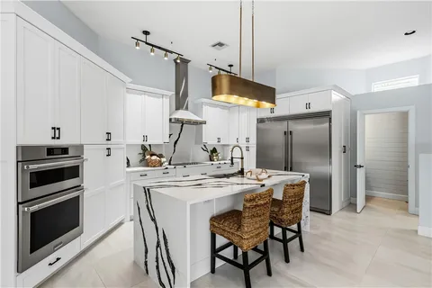 a kitchen with stainless steel appliances a stove a sink island and a refrigerator