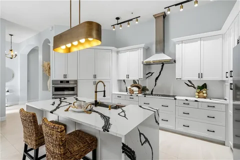 a kitchen with a sink cabinets and chandelier