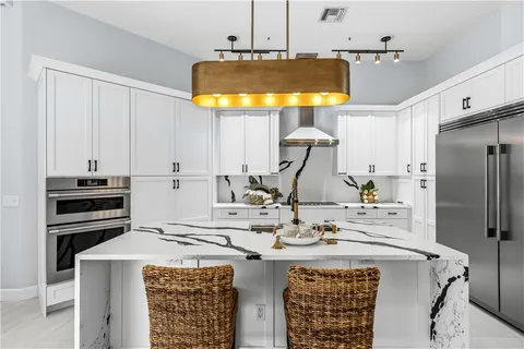 a kitchen with a sink a stove and chairs