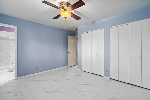 an empty room with closet and a chandelier fan