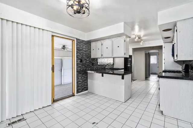 a kitchen with granite countertop white cabinets and stainless steel appliances