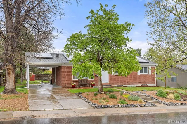 a front view of a house with a yard and potted plants