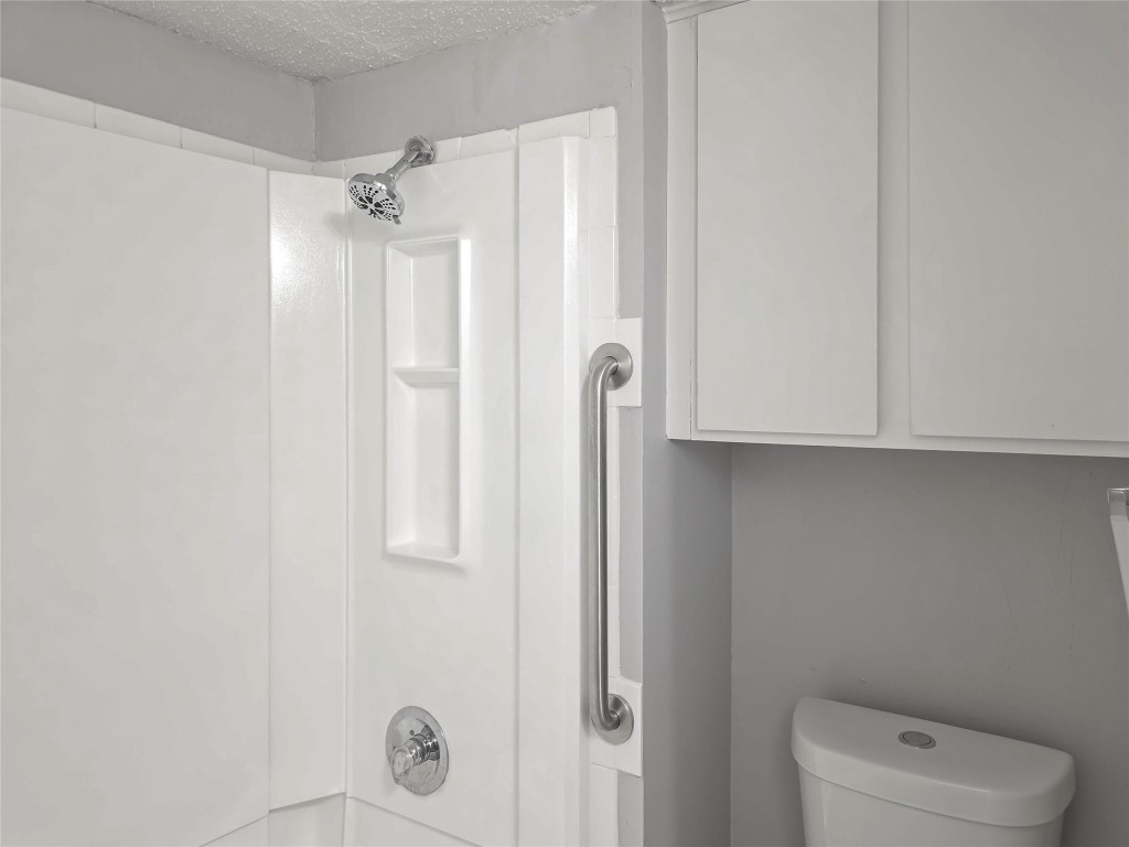 2401 Leon Street, Unit 110 Austin, TX 78705 - Photo 9 of 13 Full bathroom featuring a textured ceiling and toilet