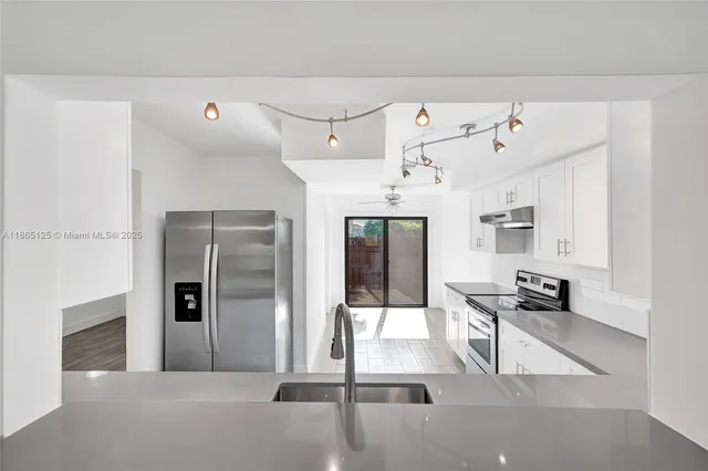 a hallway with a stove and a refrigerator