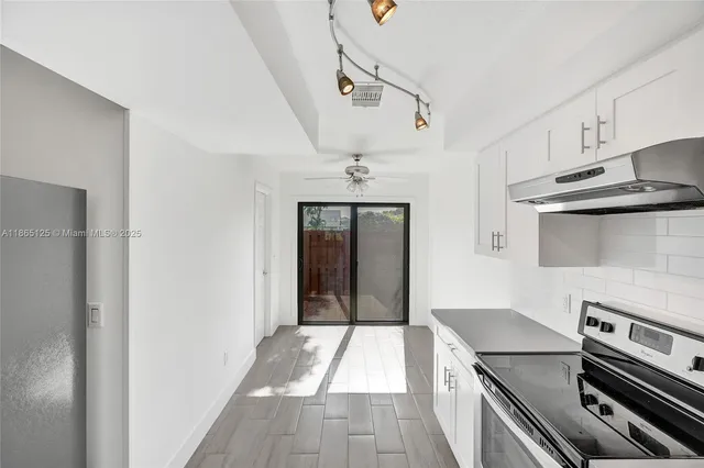 a kitchen with a refrigerator and a stove top oven