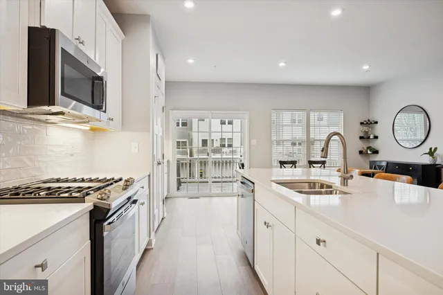 a kitchen with stainless steel appliances a sink a stove and a microwave