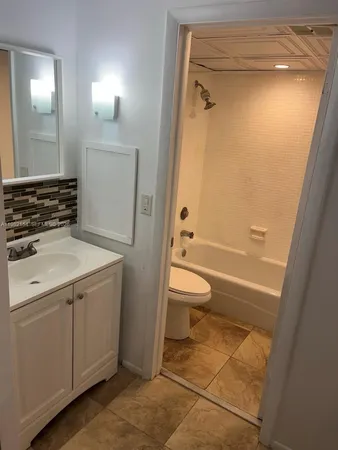 a bathroom with a granite countertop sink toilet and shower