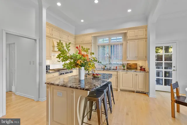 a kitchen with kitchen island granite countertop a table and chairs in it