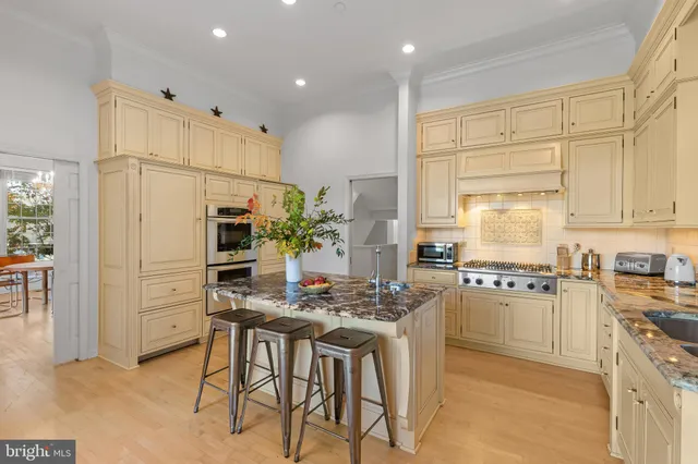 a kitchen with stainless steel appliances kitchen island granite countertop a refrigerator and a stove top oven