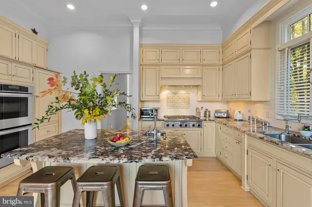 a kitchen with stainless steel appliances kitchen island granite countertop a table and chairs in it