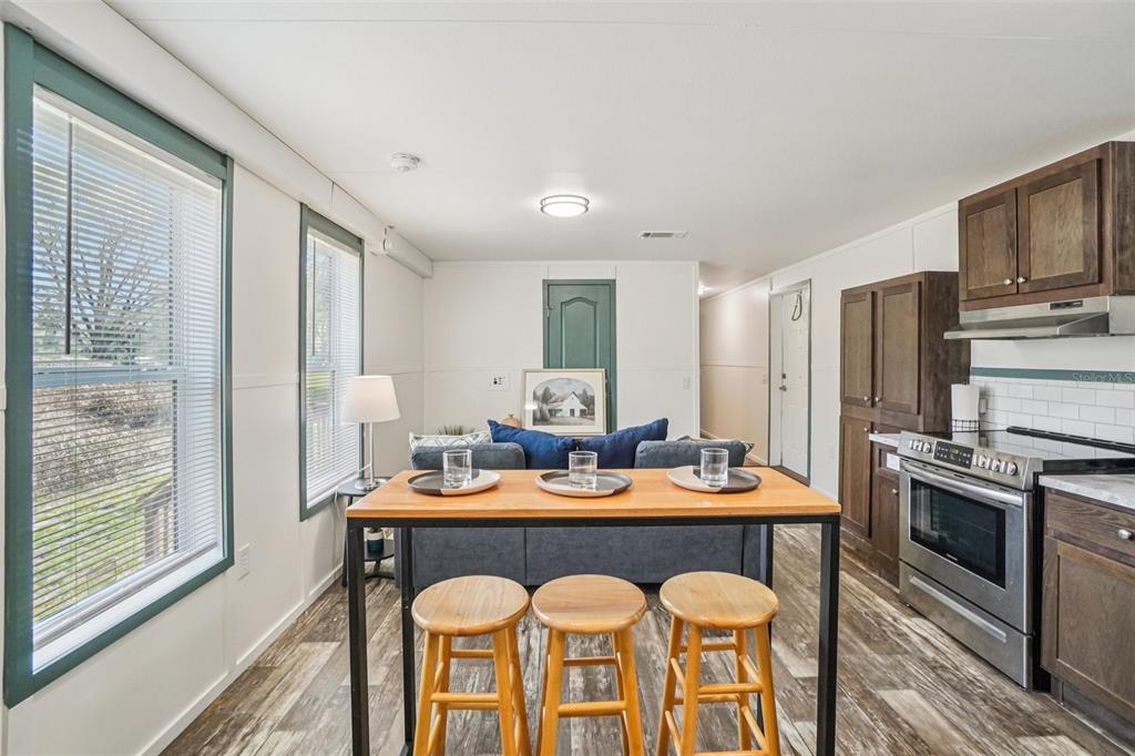 808 Southwest 124th Lane Webster, FL 33597 - Photo 6 of 18 a dining room with stainless steel appliances granite countertop a table chairs and a refrigerator