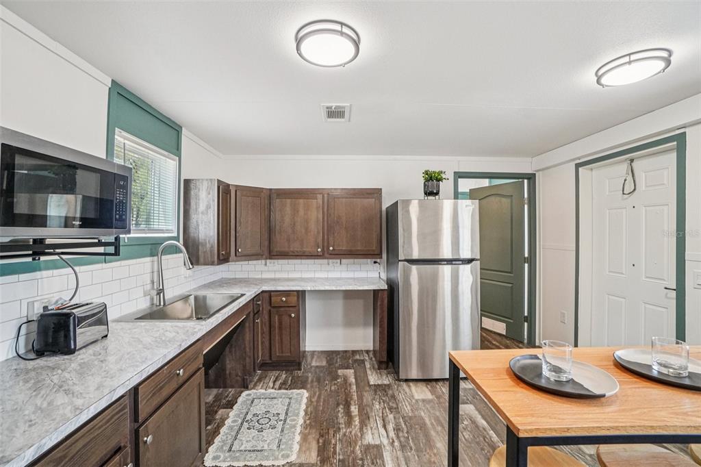 808 Southwest 124th Lane Webster, FL 33597 - Photo 8 of 18 a kitchen with stainless steel appliances granite countertop a refrigerator a stove and a sink