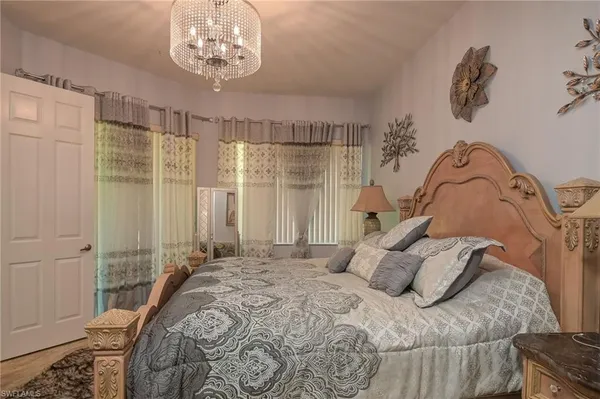 a bedroom with a bed and a chandelier