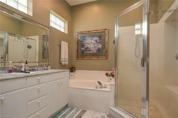 a bathroom with a tub a sink and mirror