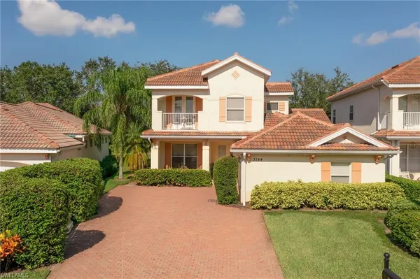 a front view of a house with a yard and lake view