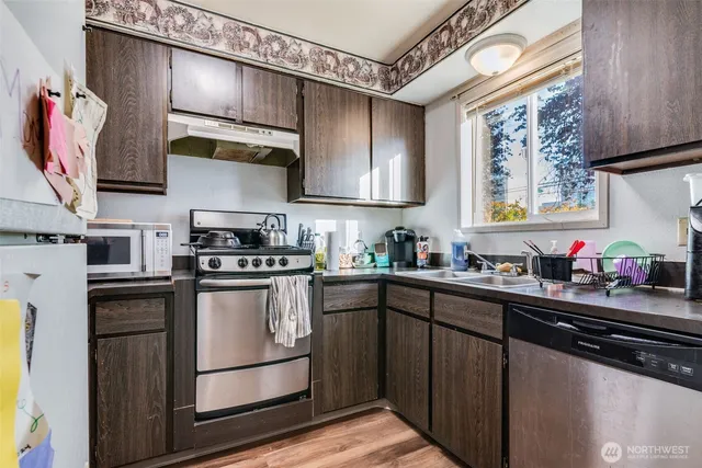 a kitchen with stainless steel appliances granite countertop a sink stove and refrigerator