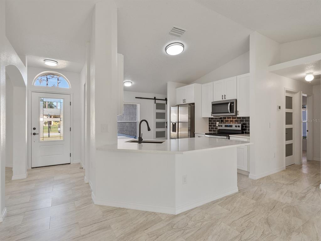 3215 Colusa Street Deltona, FL 32738 - Photo 14 of 32 a large white kitchen with stainless steel appliances