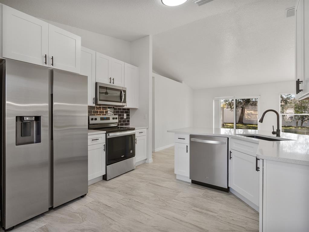 3215 Colusa Street Deltona, FL 32738 - Photo 16 of 32 a kitchen with a refrigerator sink and stove