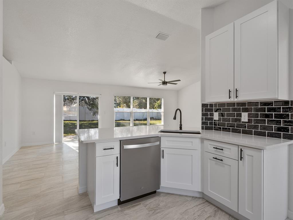 3215 Colusa Street Deltona, FL 32738 - Photo 17 of 32 a kitchen with white cabinets and sink