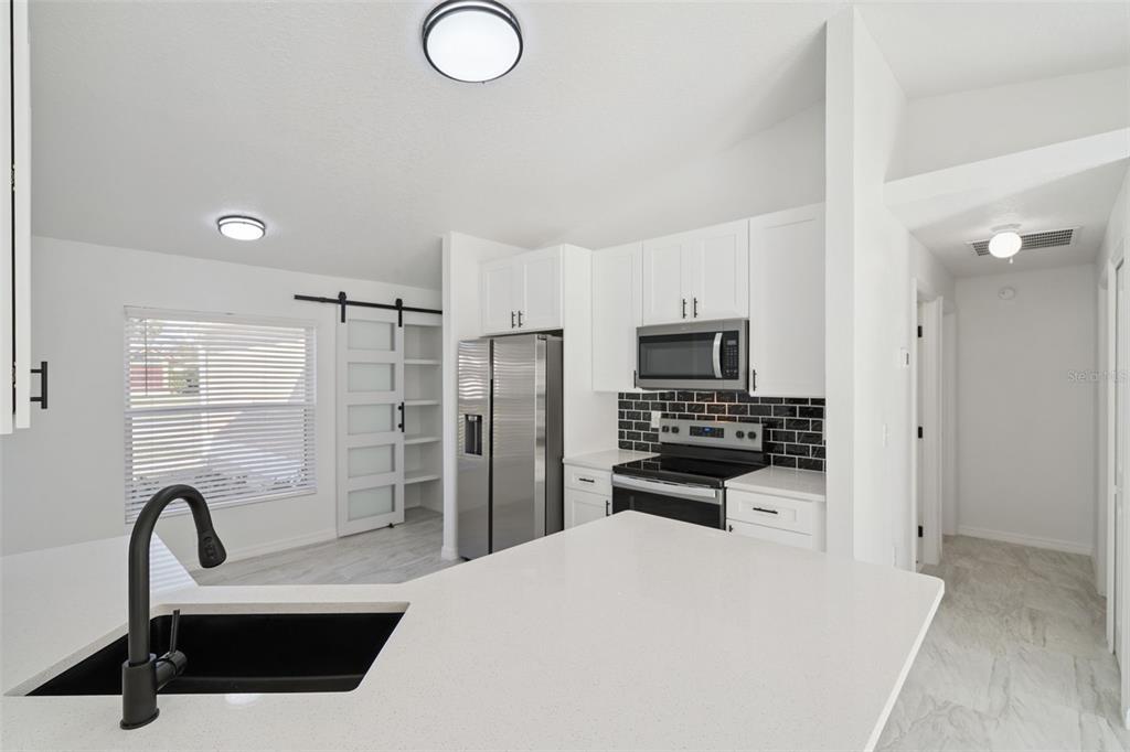 3215 Colusa Street Deltona, FL 32738 - Photo 18 of 32 a kitchen with stainless steel appliances kitchen island a refrigerator sink and stove